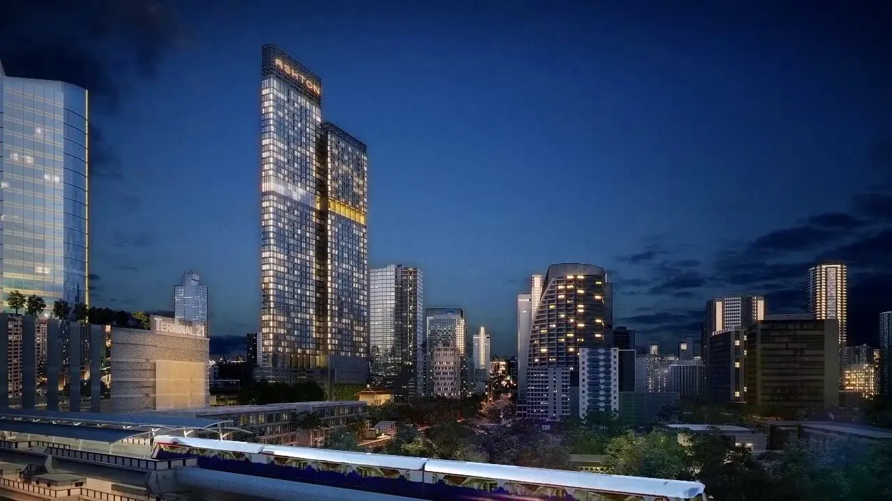 City skyline at night with illuminated skyscrapers, dominated by a tall building labeled 