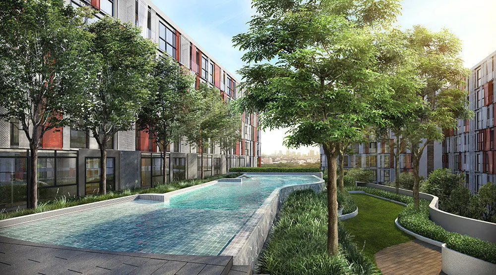 Modern apartment complex with a pool and landscaped garden, surrounded by tall trees and sunlight streaming over the buildings.