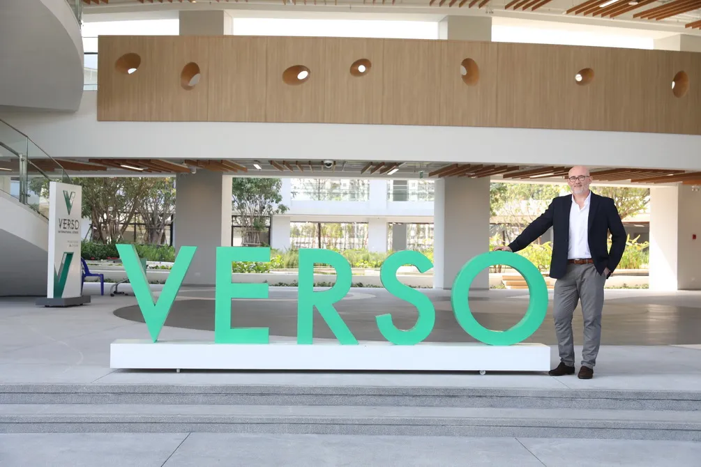A person stands next to a large green 