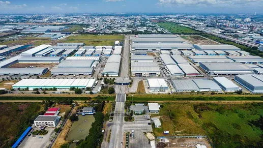 ภาพถ่ายทางอากาศของนิคมอุตสาหกรรมขนาดใหญ่ที่มีโกดังสินค้าหลายแห่ง ถนน และพื้นที่สีเขี