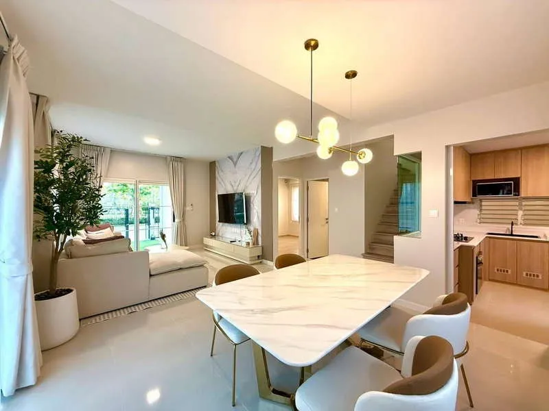 article image - Modern open-plan living and dining area with a marble table, stylish chandelier, cozy sofa, TV, and minimalist kitchen. Modern open-plan living and dining area with a marble table, stylish chandelier, cozy sofa, TV, and minimalist kitchen.