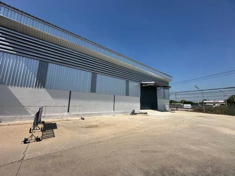 Warehouse exterior with corrugated metal siding and loading dock under a clear blue sky.