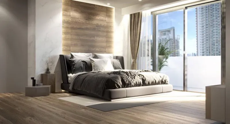 Modern bedroom with a large bed, wooden flooring, and floor-to-ceiling windows overlooking a cityscape.
