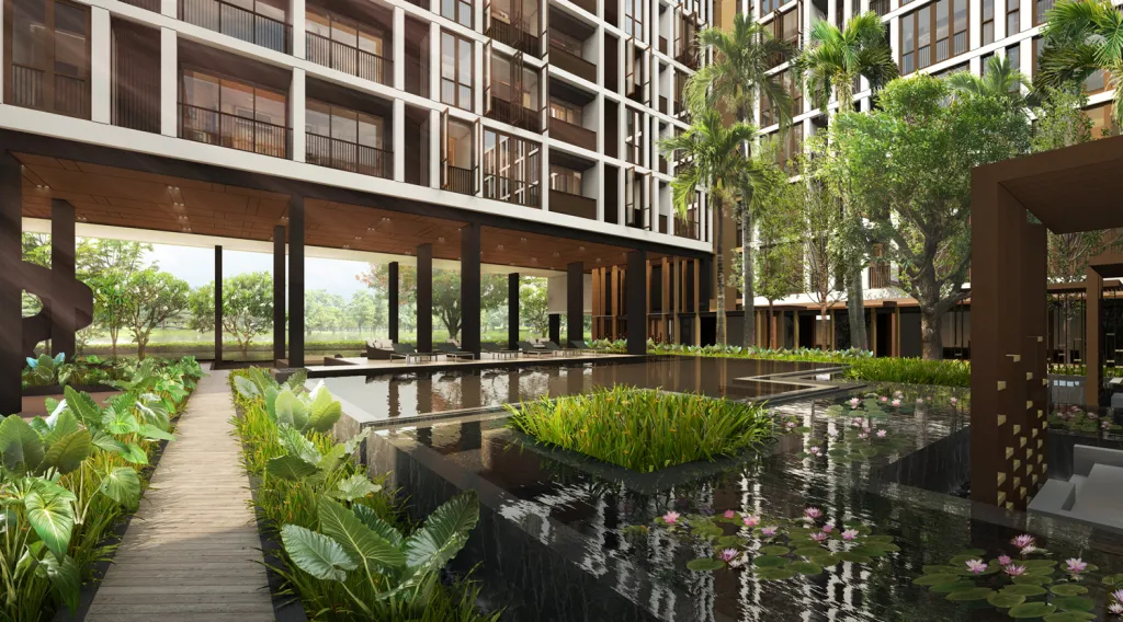 Modern building courtyard with water features, wooden walkways, lush green plants, and trees.