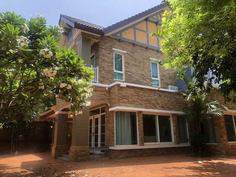 article image - Two-story house with brick exterior, white-framed windows, and a gabled roof, surrounded by greenery and flowering trees under a clear blue sky. Two-story house with brick exterior, white-framed windows, and a gabled roof, surrounded by greenery and flowering trees under a clear blue sky.