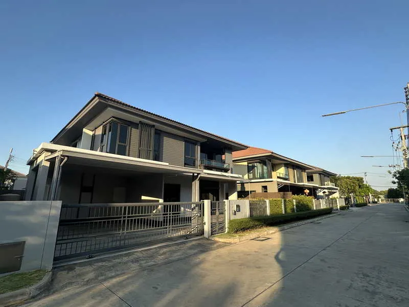 บ้านสองชั้นสไตล์โมเดิร์น มีประตูรั้วทางเข้า ตั้งอยู่บนถนนที่อยู่อาศัยที่เงียบสงบ ภายใ