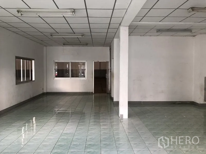 Factory for rent in Pathum Thani - Spacious office or showroom area with fluorescent lighting and tiled flooring.