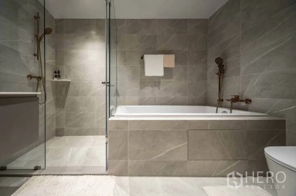 公寓 for rent in Watthana, Bangkok - 灰色瓷砖浴室，设嵌入式浴缸及独立玻璃淋浴间。