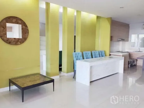 Townhouse for rent in Saphan Sung, Bangkok - Open-plan living and kitchen with lime feature wall, marble dining island and glossy floors.