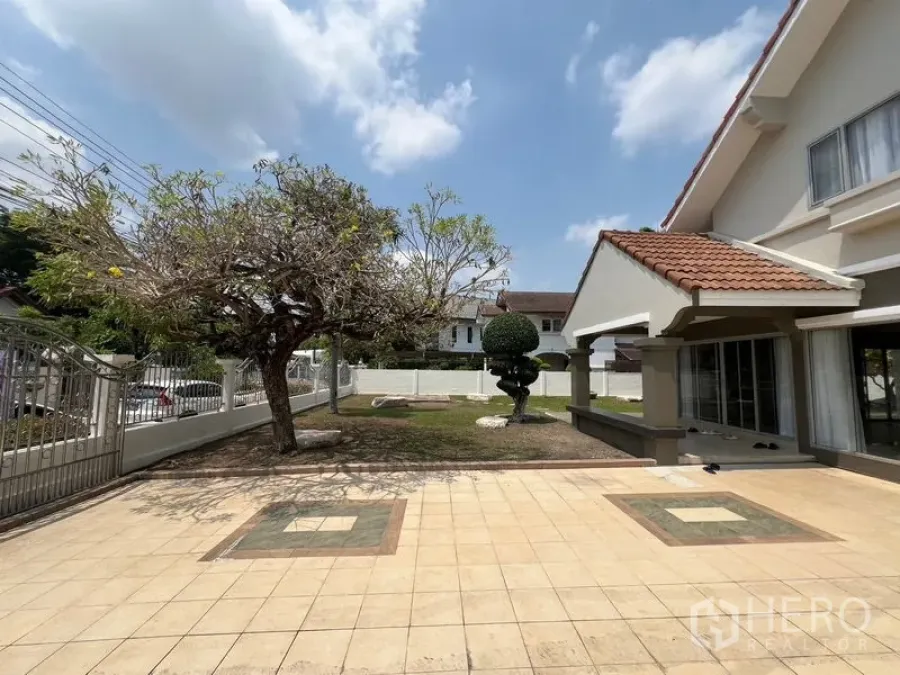 Detached House for sale in Mueang Pathum Thani, Pathum Thani - Front courtyard with tiled driveway, mature tree and the home’s covered porch.