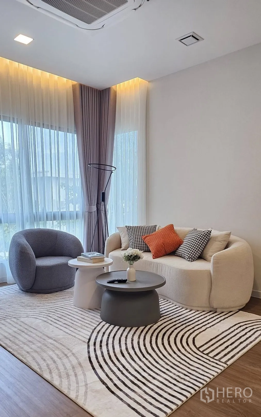 บ้านเดี่ยว for rent in Bang Phli, Samut Prakan - พื้นที่นั่งเล่นมีโซฟาทรงโค้ง เก้าอี้เสริม โต๊ะกลางซ้อน และพรมลายเส้น.