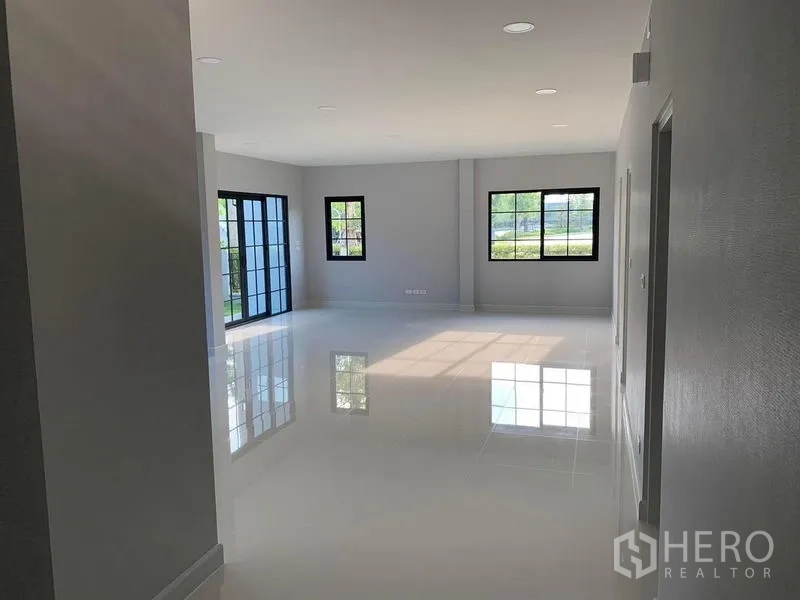 บ้าน ให้เช่าหรือขายในBang Phli, Samut Prakan - ห้องนั่งเล่นแบบเปิดโล่ง พื้นกระเบื้องเงา และหน้าต่างกรอบดำรับแสงธรรมชาติ