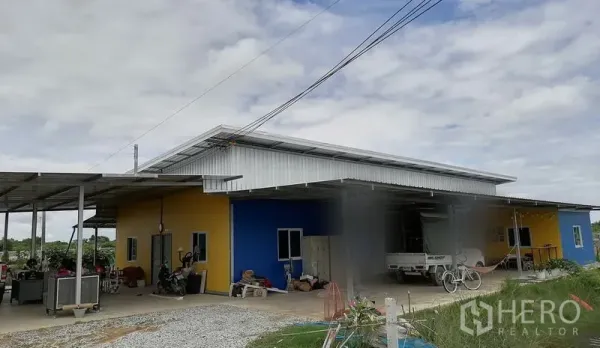 ที่ดิน ขายในBan Pho, Chachoengsao - ด้านหน้าโกดังและลานทำงาน พร้อมหลังคาเหล็กและรถจอด