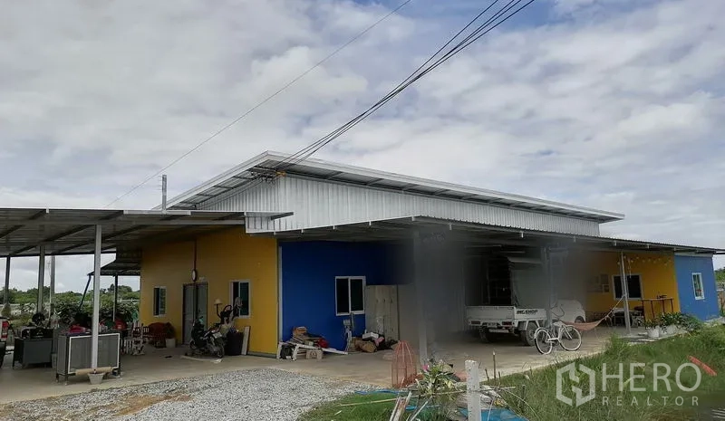 ที่ดิน ขายในBan Pho, Chachoengsao - ด้านหน้าโกดังและลานทำงาน พร้อมหลังคาเหล็กและรถจอด
