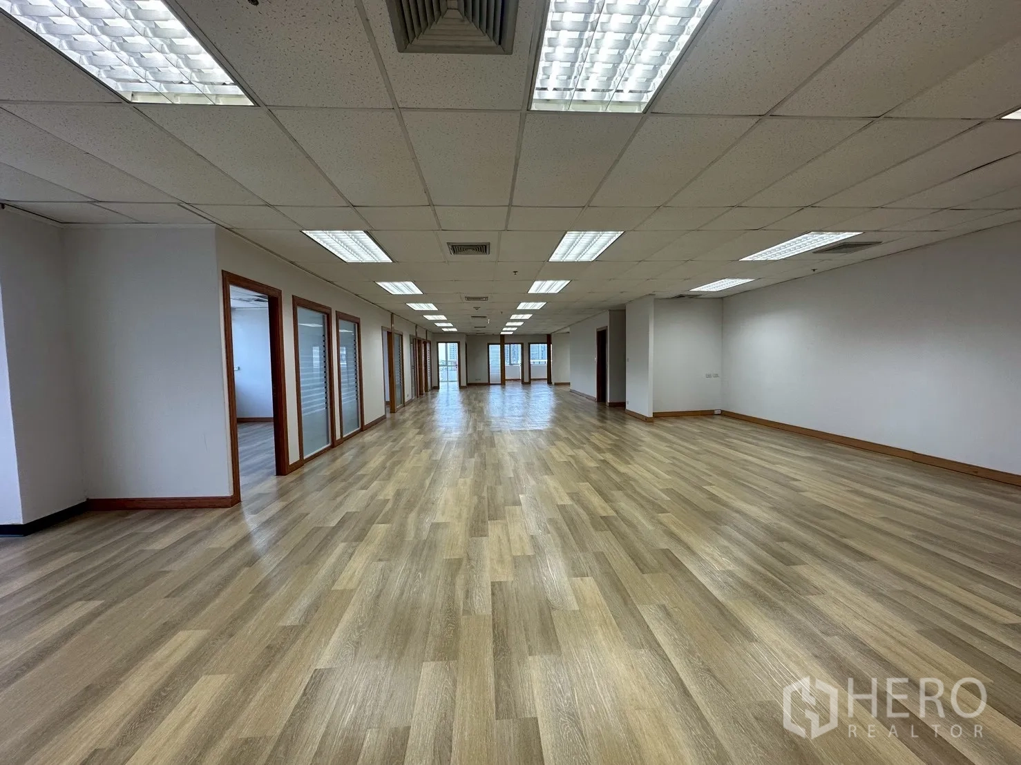 สำนักงาน ให้เช่า - พื้นที่ออฟฟิศแบบเปิด พร้อมห้องทำงานกั้นกระจกหลายห้องและไฟฝ้าเพดานสว่าง