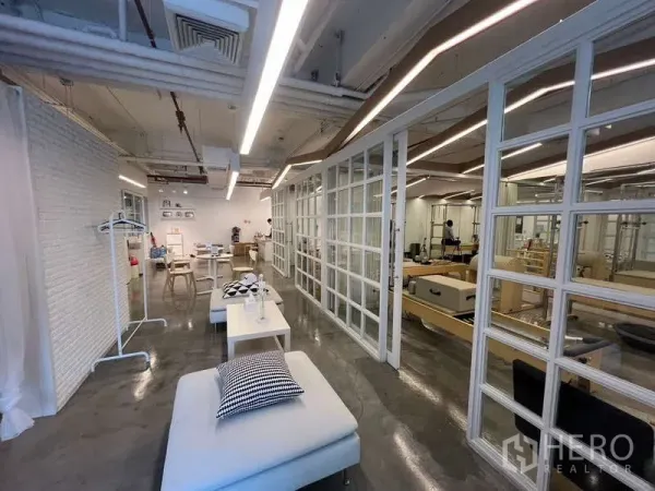 零售空间 出租 - 宽敞零售区，格栅玻璃隔断、躺椅与抛光水泥地。