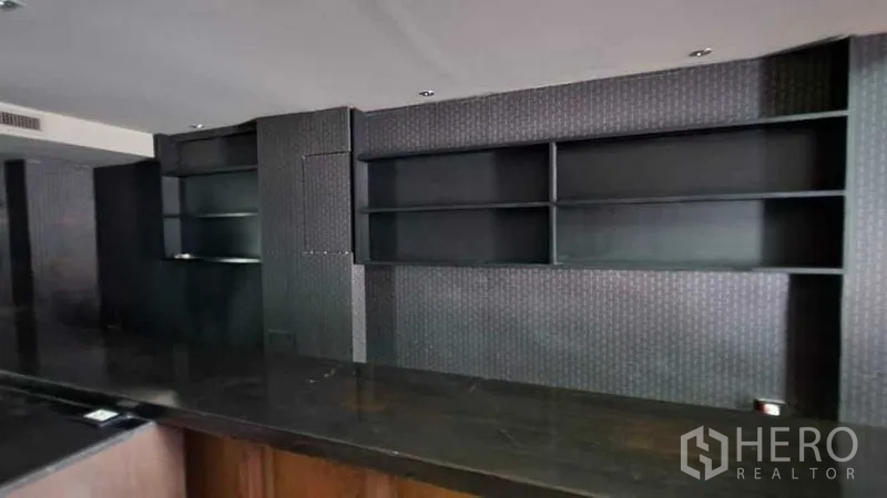 店屋 出租在Khlong Toei, Bangkok - 柜台后方的黑色内嵌陈列架，适合商品展示。