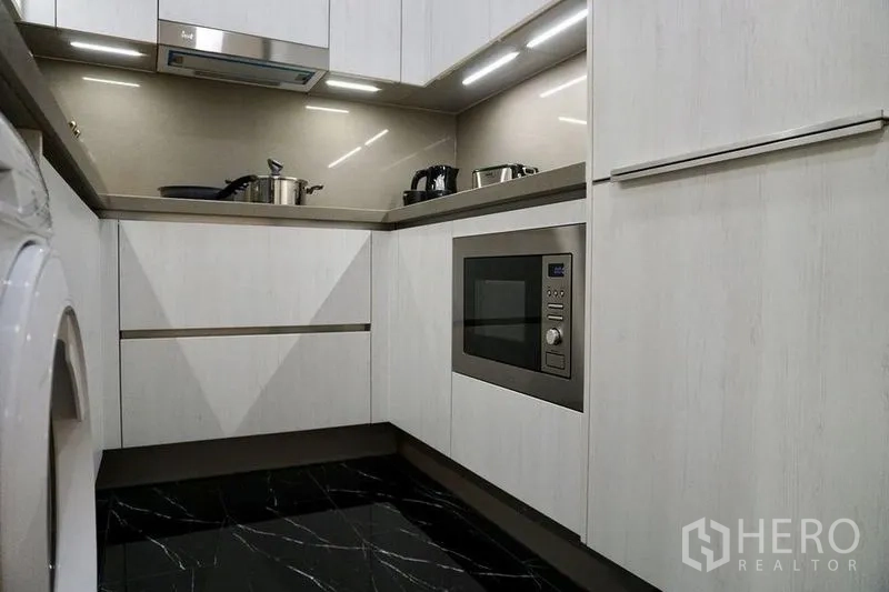 คอนโด ให้เช่าในKhlong Toei, Bangkok - มุมครัวส่วนล่างบิวท์อินพร้อมไมโครเวฟ พื้นกระเบื้องดำเงาและตู้สีขาว
