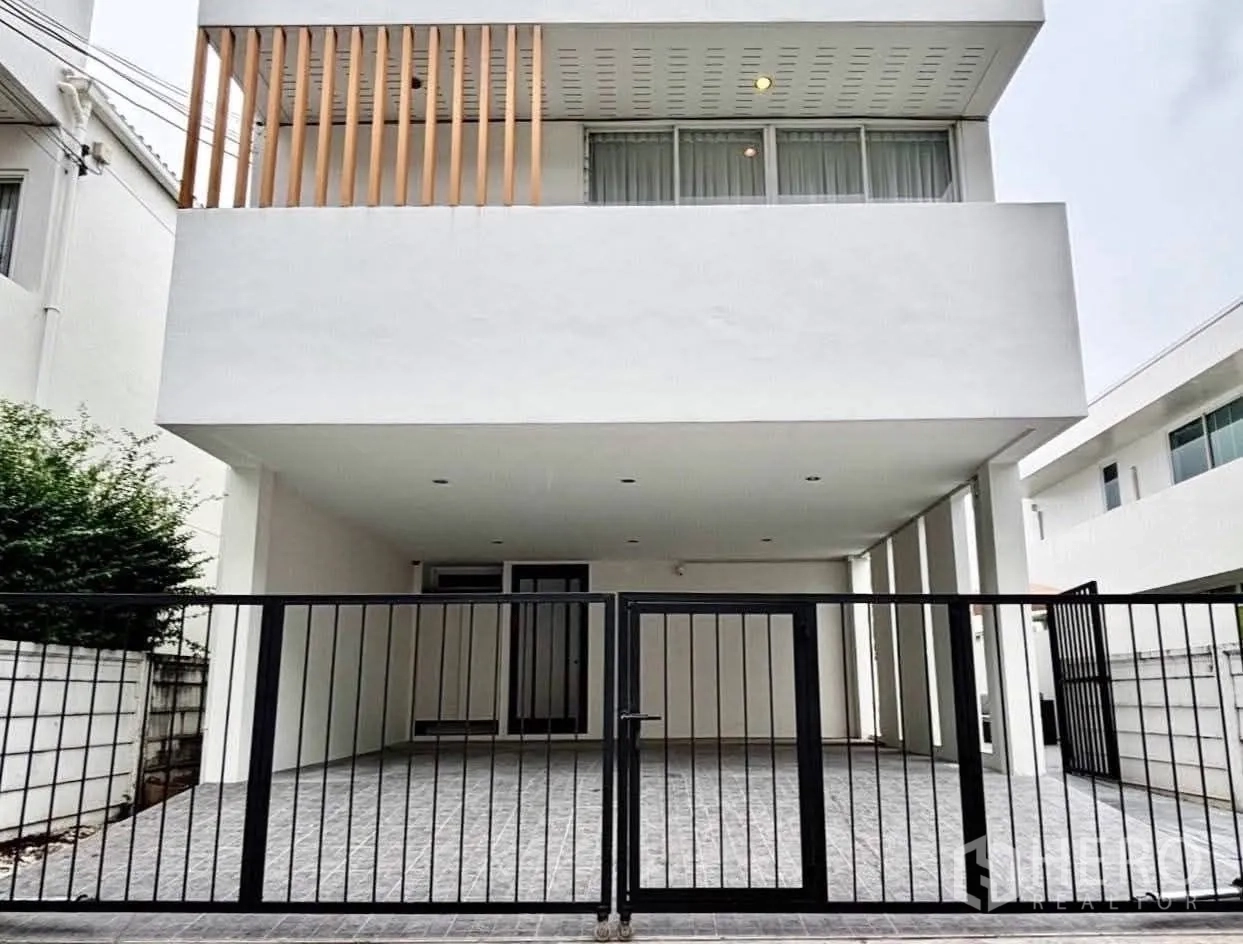 独栋房屋 for rent in Saphan Sung, Bangkok - 现代白色独栋住宅外立面，带大门与有顶车位。