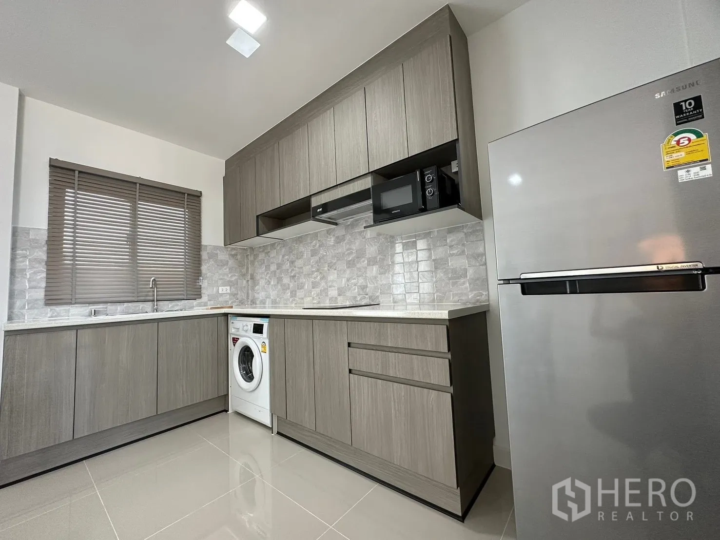 Townhouse for rent in Bang Phli, Samut Prakan - Kitchen angle highlighting tall refrigerator and upper cabinetry.