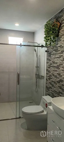 联排别墅 出租或出售在Saphan Sung, Bangkok - 卫浴设玻璃淋浴间、石材纹理背景墙与坐便器。
