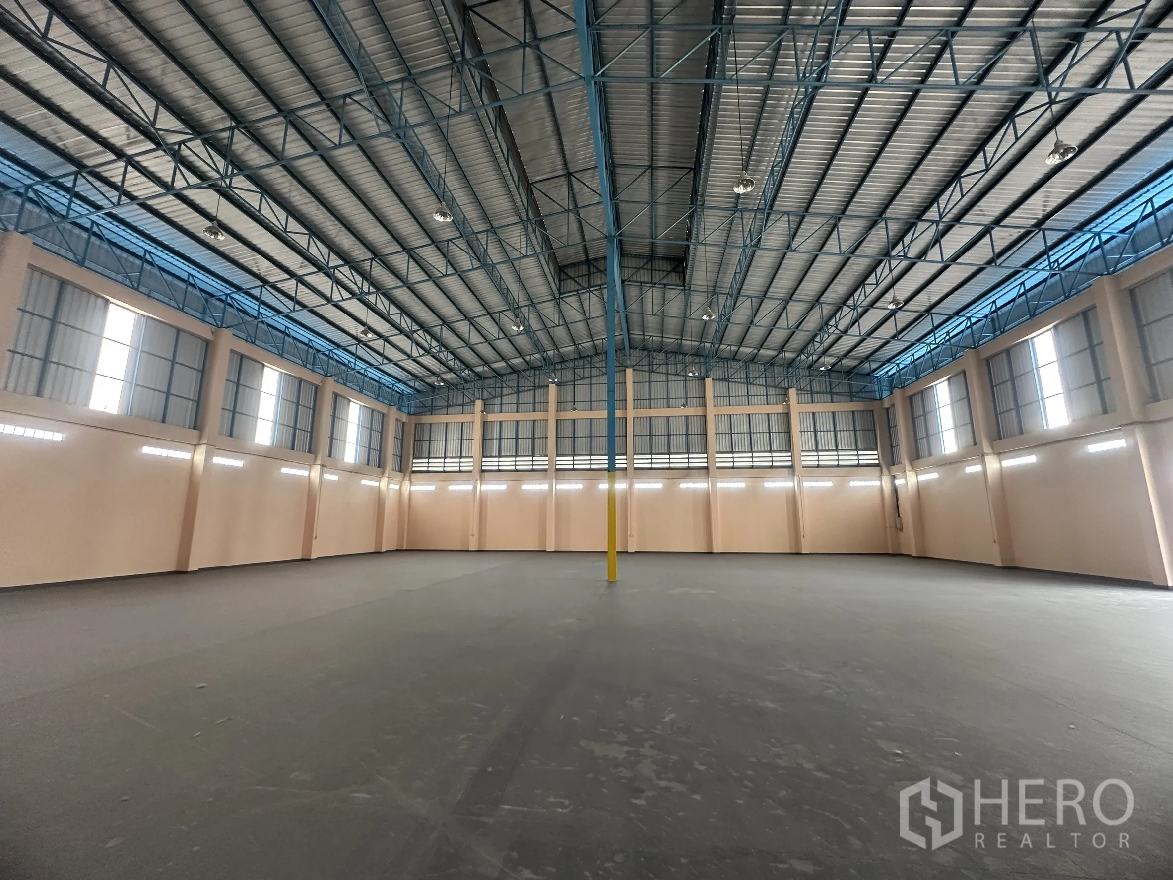 Warehouse for rent in Lat Lum Kaeo, Pathum Thani - Warehouse interior corner showing open floor area and ventilation panels beneath the roof.
