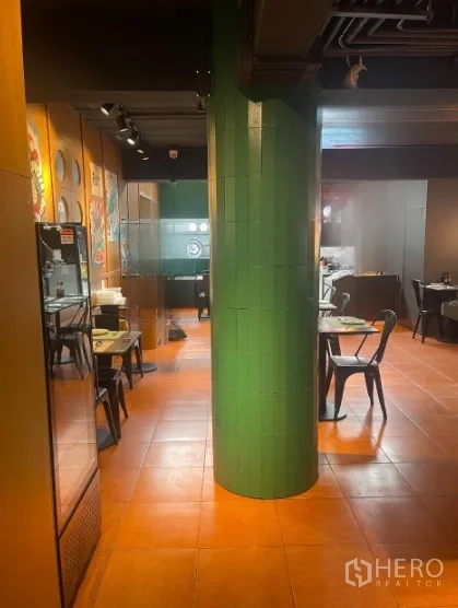 店屋 出租在Watthana, Bangkok - 走道视角的用餐区，绿色瓷砖立柱与墙面装饰。