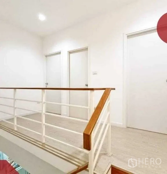 Home Office for rent or sale - Bright upstairs landing with white railing and three interior doors.