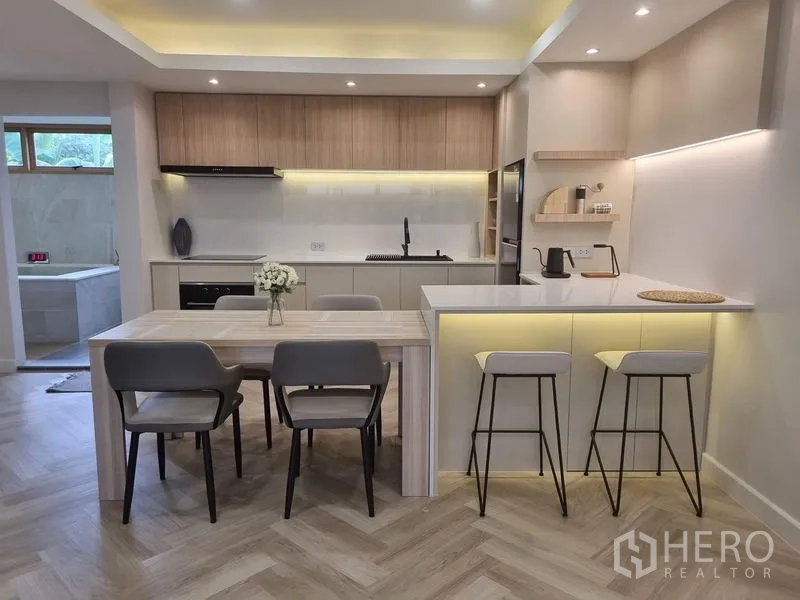 ทาวน์เฮาส์ ให้เช่าหรือขาย - ครัวสมัยใหม่พร้อมเคาน์เตอร์บาร์ โต๊ะทานอาหาร และไฟใต้ตู้
