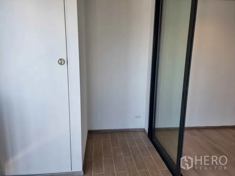 Condominium for sale in Phaya Thai, Bangkok - Small enclosed balcony or utility nook with storage cabinet and sliding door.