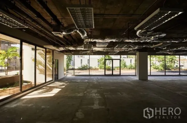 办公空间 出租在Bangkok - 带落地玻璃的办公空间，面向绿化露台，外露顶与水泥地面。