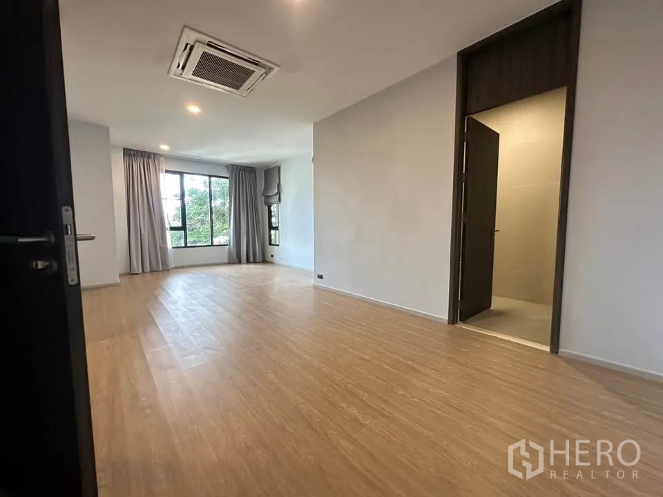 Detached House for sale in Watthana, Bangkok - Bright bedroom with an en-suite doorway and wide windows.