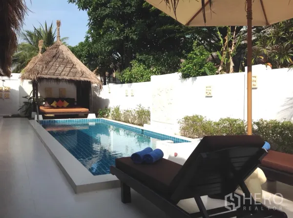 Detached House for sale in Hua Hin, Prachuap Khiri Khan - Private courtyard pool with sun loungers and a thatched sala amid tropical greenery.