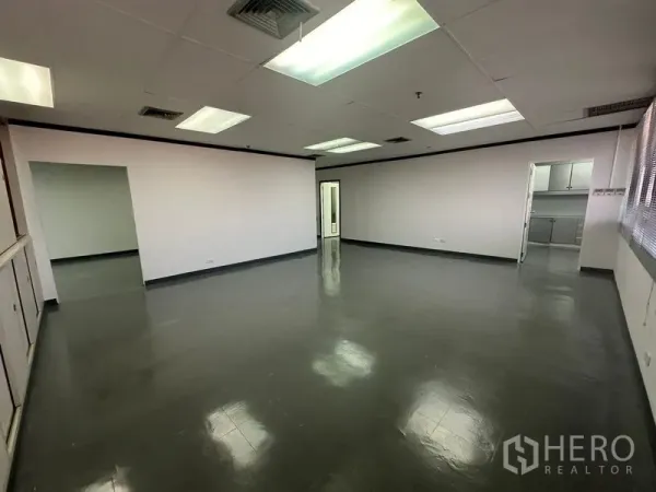 办公空间 出租在Yan Nawa, Bangkok - 宽阔工作区，整面窗与内置储物柜，吊顶灯充足。