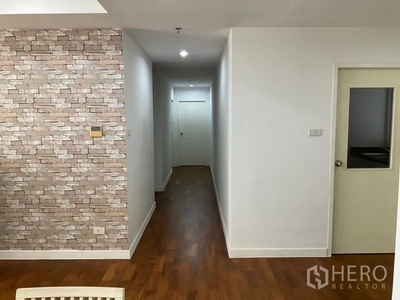 คอนโด ให้เช่าในKhlong Toei, Bangkok - โถงทางเดินพื้นไม้และผนังลายอิฐ นำไปสู่ห้องนอนและครัว