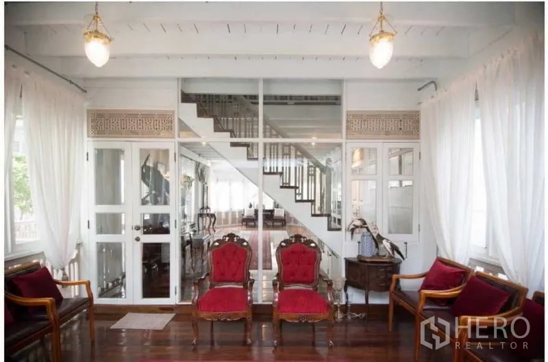 Detached House for rent in Bang Rak, Bangkok - Reception area with red upholstered chairs facing a glass partition and staircase.