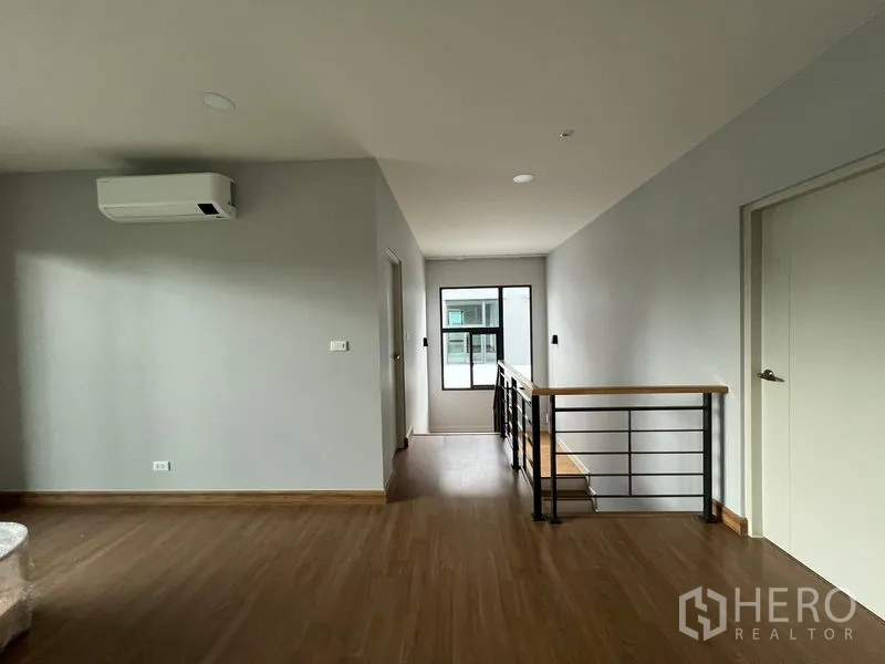 Detached House for rent or sale in Bang Phli, Samut Prakan - Upstairs hallway and staircase with metal railing and natural light from the window.