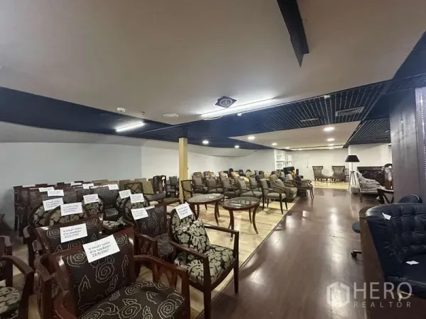 零售空间 出租 - 展厅一隅，成排椅子摆放在木地板上，吸音网格吊顶。