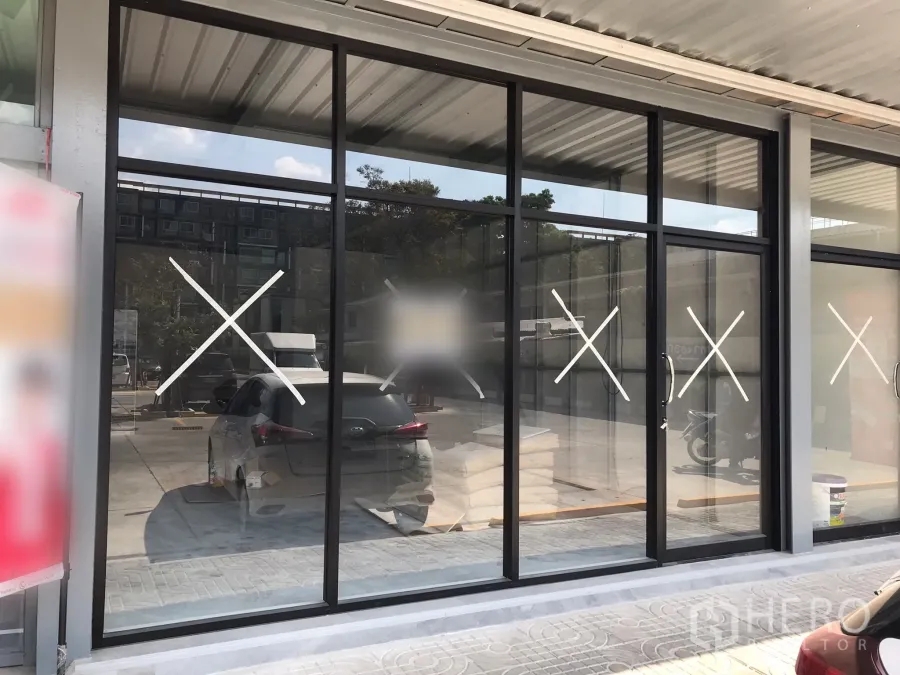 零售空间 出租在Khlong Toei, Bangkok - 临街零售铺面，落地玻璃橱窗，黑色铝框，带遮雨走道与门前停车位。