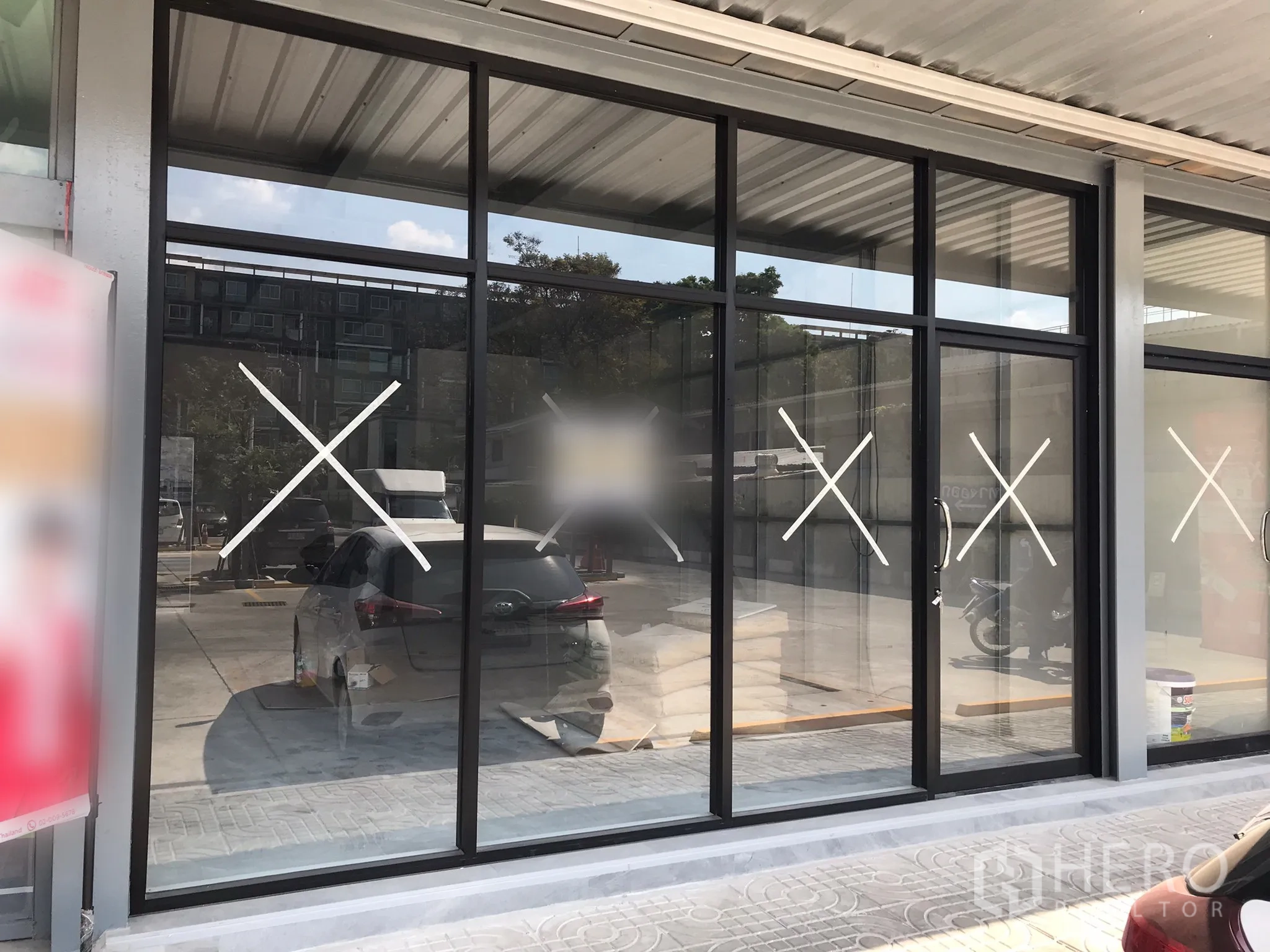 零售空间 出租在Khlong Toei, Bangkok - 临街零售铺面，落地玻璃橱窗，黑色铝框，带遮雨走道与门前停车位。