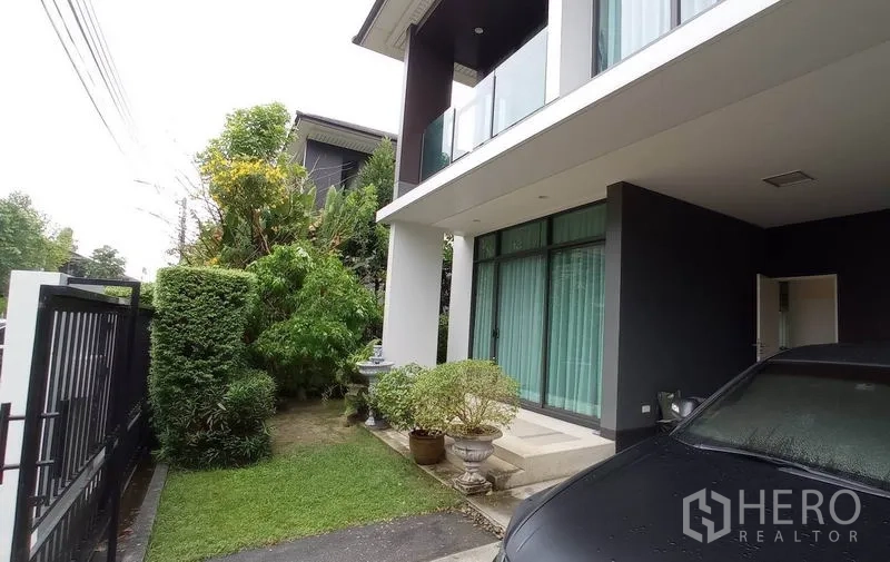 Detached House for rent in Bang Kapi, Bangkok - Side garden with lawn and shrubs beside the covered carport and front porch.