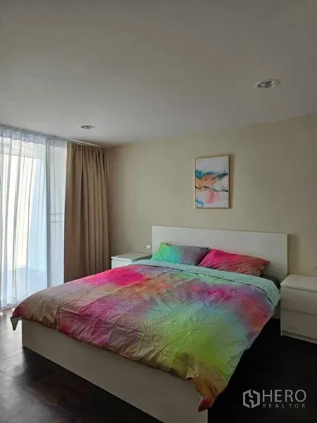 ทาวน์เฮาส์ ให้เช่าในBang Na, Bangkok - ห้องนอนพร้อมเตียงควีนผ้าปูสีสัน โต๊ะข้างเตียง และผ้าม่านบานหน้าต่าง