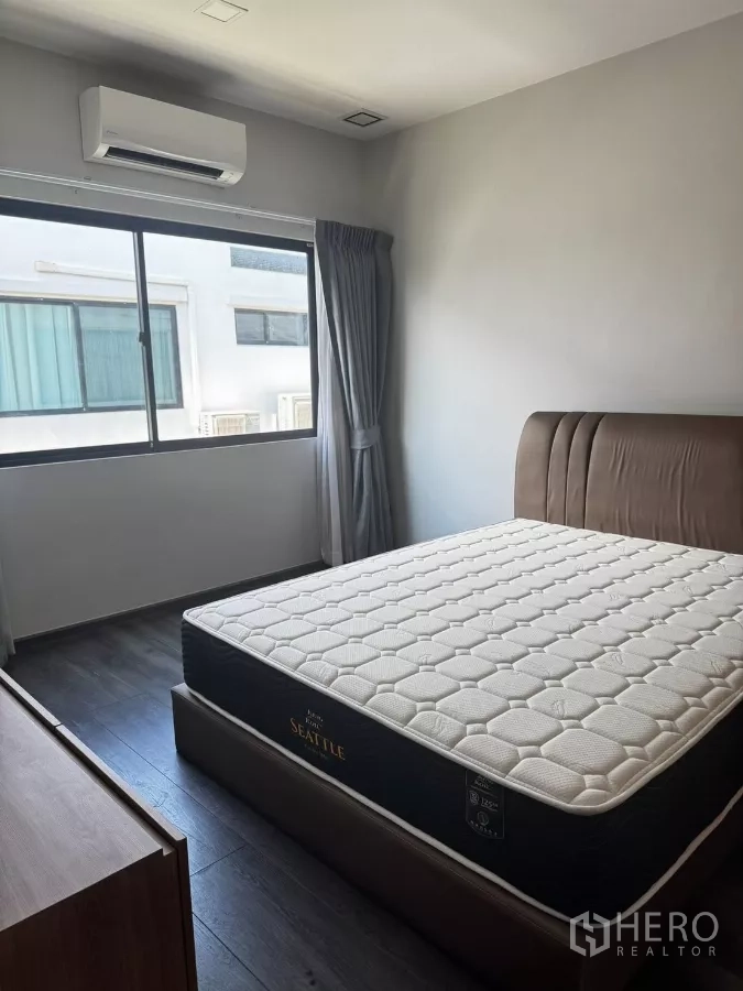Townhouse for rent in Bang Phli, Samut Prakan - Guest bedroom with queen bed, wide window, neutral walls, and AC unit.