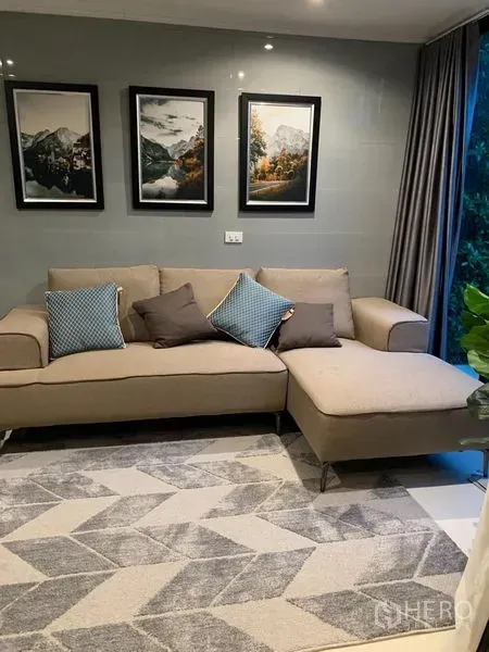 สำนักงานที่บ้าน ให้เช่าในSaphan Sung, Bangkok - ห้องนั่งเล่นโทนอบอุ่น โซฟาเข้ามุมสีเบจ พรมลายเรขาคณิต และภาพติดผนัง