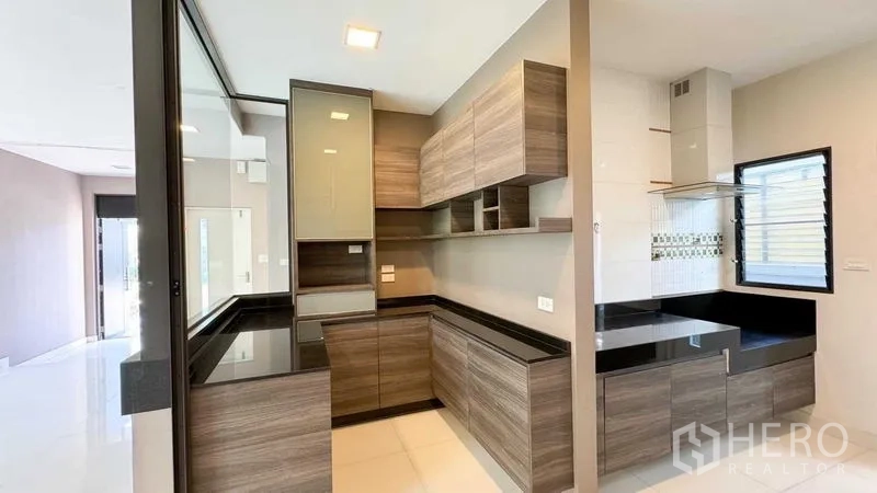 บ้าน ขายในBang Kapi, Bangkok - ครัวบิวท์อินรูปตัวแอล ตู้ลายไม้ ท็อปหินสีดำ