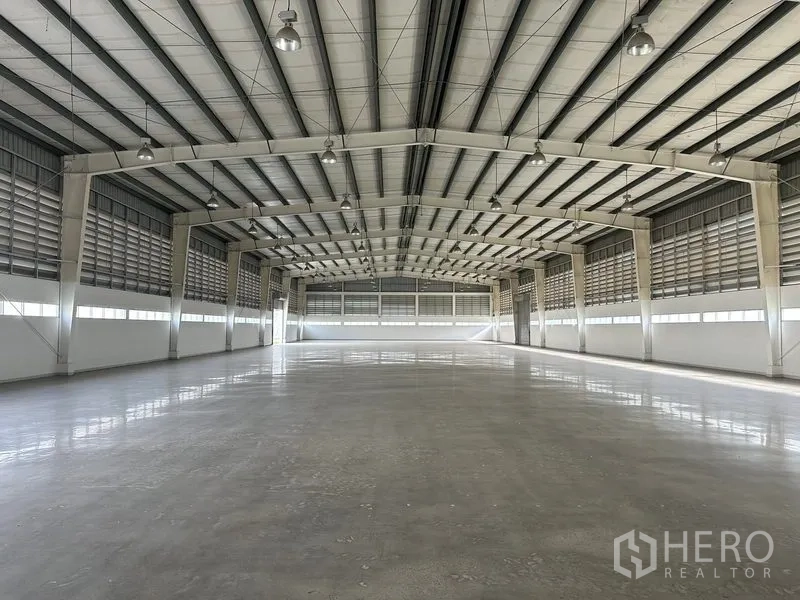 工厂 出租在Phra Nakhon Si Ayutthaya - 空旷仓库展示无柱大空间、百叶侧墙与明亮照明。