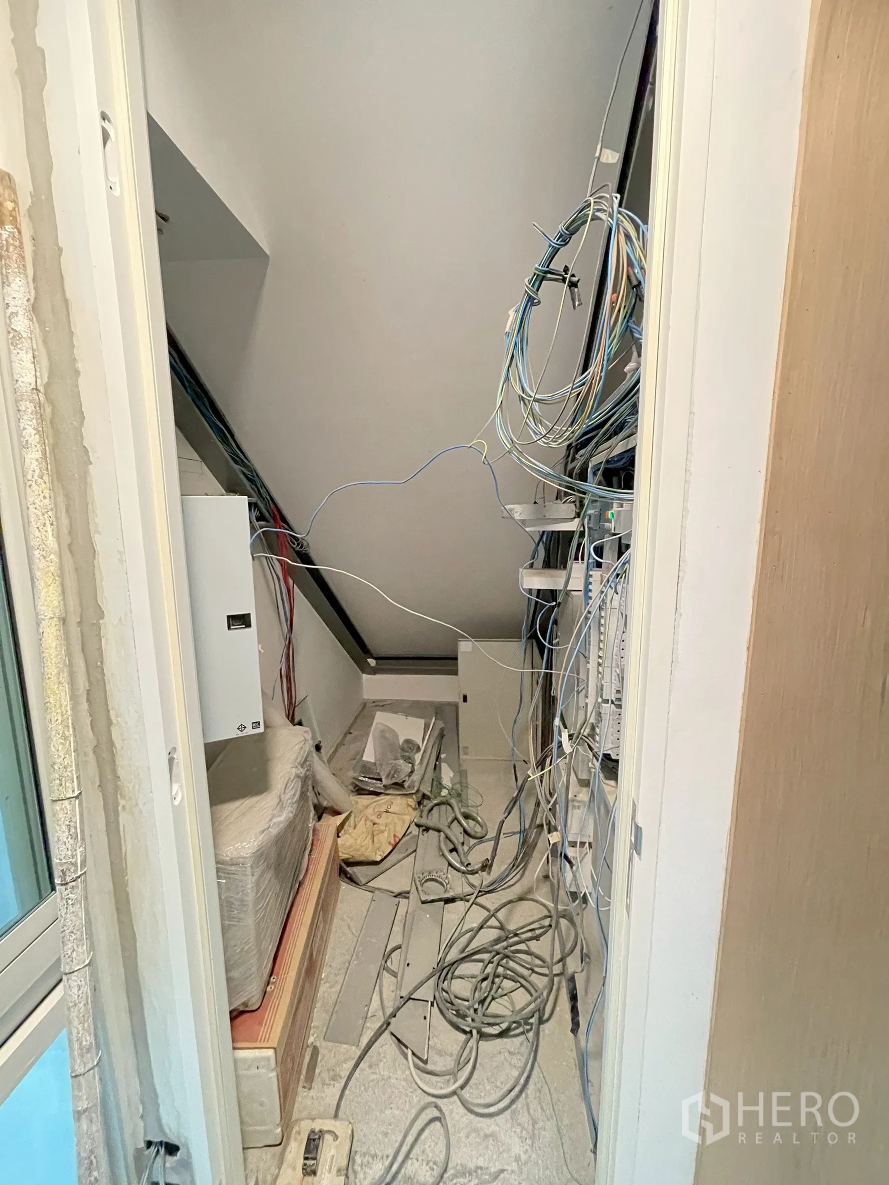 Detached House for sale in Bang Phli, Samut Prakan - Service room with exposed electrical cabling and equipment under stairs.