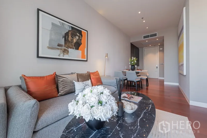 คอนโด ขายในWatthana, Bangkok - ห้องนั่งเล่นสไตล์โมเดิร์น หมอนอิงสีส้ม โต๊ะกลางหิน และชุดโต๊ะทานข้าวในย่านทองหล่อ