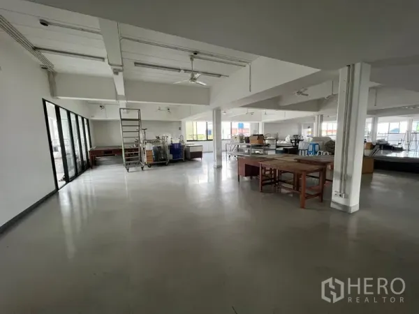 Office Space for rent in Mueang Samut Prakan, Samut Prakan - Spacious workspace with high ceilings, glass wall and worktables.