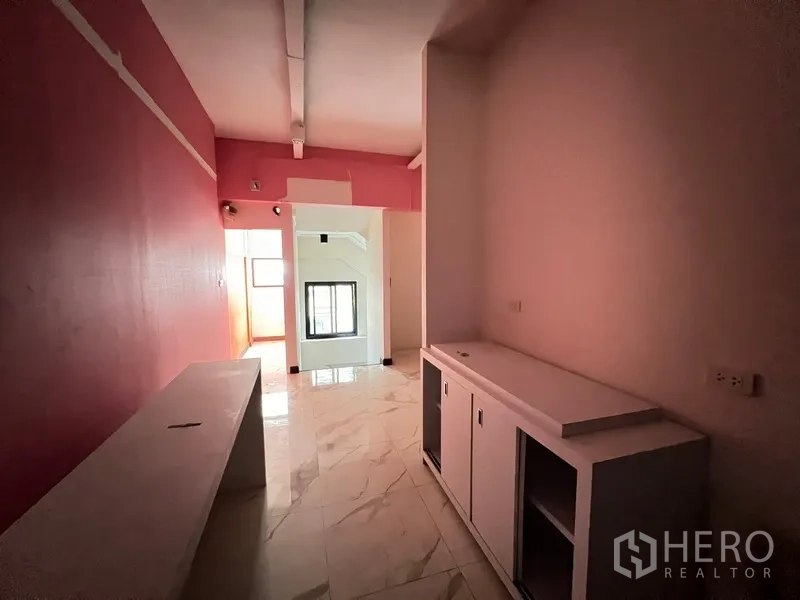 店屋 出租在Watthana, Bangkok - 楼上走廊，粉色墙面与白色内置柜体。